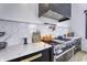 Contemporary kitchen featuring a stainless steel range, marble countertops, and sleek black cabinetry with gold hardware at 8695 Morgan Dr, Fishers, IN 46038