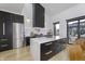 Sleek kitchen with black cabinets, a marble backsplash, stainless steel appliances, and an island with seating at 8695 Morgan Dr, Fishers, IN 46038