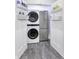 Laundry closet with stacked washer and dryer, shelving, and a mini refrigerator for added convenience at 8695 Morgan Dr, Fishers, IN 46038