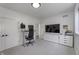 Bright office featuring a modern standing desk, comfortable seating, and built-in storage under the TV at 8695 Morgan Dr, Fishers, IN 46038