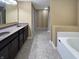 Bathroom featuring double sink vanity, tile flooring, and soaking tub at 930 Penstock Ct, Avon, IN 46123