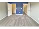 A bedroom features blue accent wall, closet entrances, soft gray walls, plush carpeting, and natural light at 930 Penstock Ct, Avon, IN 46123