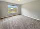 Bright bedroom showcasing soft carpeting, a window with natural light, and neutral wall color at 930 Penstock Ct, Avon, IN 46123