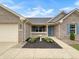 Close up of the front entrance of a home with lovely landscaping features and a blue door at 930 Penstock Ct, Avon, IN 46123