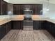 Updated kitchen features stainless steel appliances, granite countertops, and dark wood cabinets at 930 Penstock Ct, Avon, IN 46123