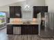 Well-lit kitchen with dark cabinets, stainless steel appliances, granite counter tops, and hardwood floors at 930 Penstock Ct, Avon, IN 46123