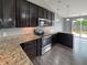 Modern kitchen features stainless steel appliances, granite countertops, and dark wood cabinets at 930 Penstock Ct, Avon, IN 46123