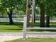 Scenic backyard view showcasing mature trees, a white fence, and a tranquil lake in the distance at 9451 S Amanda Dr, Claypool, IN 46510