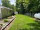 Expansive backyard with lush green lawn, landscaping, and a large propane tank at 9451 S Amanda Dr, Claypool, IN 46510