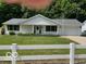 Charming single story home with a well-manicured lawn and a white picket fence at 9451 S Amanda Dr, Claypool, IN 46510