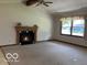 Open living room with fireplace, window, and neutral-colored carpet at 9451 S Amanda Dr, Claypool, IN 46510