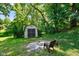 View of backyard firepit area with shed and mature trees at 955 Wood Creek Pl, Greenwood, IN 46142