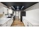 Galley style kitchen featuring white countertops, cabinets and black appliances at 955 Wood Creek Pl, Greenwood, IN 46142