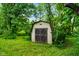 Backyard shed with double doors surrounded by grass and trees at 955 Wood Creek Pl, Greenwood, IN 46142
