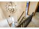 Elegant staircase with modern chandelier, carpeted steps, and a view of the entryway at 955 Wood Creek Pl, Greenwood, IN 46142