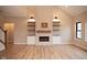 Bright living room featuring a modern fireplace, built-in shelves, and light wood flooring at O Legacy Estates-Lot 5, Mooresville, IN 46158