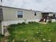 Exterior view of the home showcasing the siding, green lawn, and a convenient entry porch with steps at 10129 Peartree Rd, Indianapolis, IN 46235
