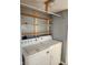 Functional laundry room with washer, dryer hookups, and practical shelving for storage at 10129 Peartree Rd, Indianapolis, IN 46235
