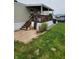 Cozy porch with wood railing, stairs, and brick pavers leading to a green lawn at 10129 Peartree Rd, Indianapolis, IN 46235