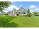 Spacious backyard showcasing green lawn, mature trees, and well-kept landscaping at 1051 Arrowwood Dr, Carmel, IN 46033
