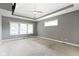 Spacious main bedroom featuring tray ceilings, three windows, and neutral-colored carpet at 1051 Arrowwood Dr, Carmel, IN 46033