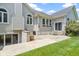 Exterior view of a home with a sliding glass door to a walkout basement and a stone patio at 1051 Arrowwood Dr, Carmel, IN 46033