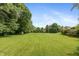 Sprawling backyard with lush green grass and mature trees provides serene space at 1120 Mill Run Overlook, Noblesville, IN 46062
