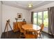 Bright dining room with wood table, chairs, and large window offering a serene backyard view at 1120 Mill Run Overlook, Noblesville, IN 46062