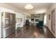 Open-concept living room featuring a stone fireplace, built-in shelving, and a view of the kitchen at 1120 Mill Run Overlook, Noblesville, IN 46062