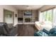 Cozy living room featuring hardwood floors, a brick fireplace, and built-in shelving at 1120 Mill Run Overlook, Noblesville, IN 46062