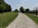Gravel driveway leading to white barns and pastures, framed by a black fence at 115 W State Road 38, Pendleton, IN 46064