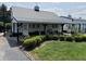 Charming white barn with black trim, landscaping and covered porch with rocking chairs at 115 W State Road 38, Pendleton, IN 46064