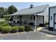 Charming white barn with black trim, landscaping and covered porch with rocking chairs at 115 W State Road 38, Pendleton, IN 46064