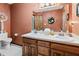 Bright bathroom featuring dual sinks, decorative elements, and wood cabinets at 13153 Tudor Dr, Carmel, IN 46033