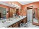 Bright bathroom featuring double sinks, a makeup vanity, and classic lighting fixtures at 13153 Tudor Dr, Carmel, IN 46033