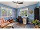 Well-lit bedroom with blue walls, ceiling fan, chair, and a desk at 13153 Tudor Dr, Carmel, IN 46033