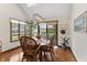 Bright dining area with wicker furniture, a glass-top table, and natural light from the windows at 13153 Tudor Dr, Carmel, IN 46033