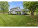 A two-story house with well-manicured landscaping, light-grey siding, and a green lawn at 13153 Tudor Dr, Carmel, IN 46033