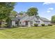 Beautiful single-Gathering home exterior with green lawn, light-grey siding, and an outdoor patio set at 13153 Tudor Dr, Carmel, IN 46033