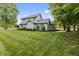 A two-story house with well-manicured landscaping, light-grey siding, and a green lawn at 13153 Tudor Dr, Carmel, IN 46033