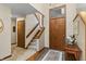 Inviting foyer with staircase, closet, and wood door with window above at 13153 Tudor Dr, Carmel, IN 46033