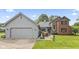 Charming two-story home with a grey garage, brick, beautiful landscaping, and a well-manicured lawn at 13153 Tudor Dr, Carmel, IN 46033