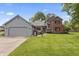 Charming home with two-car garage, lush lawn and beautiful landscaping with bright flowers at 13153 Tudor Dr, Carmel, IN 46033