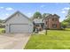 Charming home with two-car garage, concrete drive, lush lawn and landscaped front yard at 13153 Tudor Dr, Carmel, IN 46033