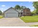 Charming home with two-car garage, concrete drive, lush lawn and landscaped front yard at 13153 Tudor Dr, Carmel, IN 46033