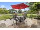 Outdoor patio with table and chairs and a red umbrella at 13153 Tudor Dr, Carmel, IN 46033