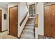 Carpeted staircase with wooden banister, window seat, and natural light at 13153 Tudor Dr, Carmel, IN 46033