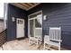Inviting back porch featuring rocking chairs, stylish wood siding, and a sliding glass door at 1452 Fletcher Ave, Indianapolis, IN 46203