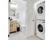Bathroom with a modern vanity and stacked laundry machines for added convenience at 1452 Fletcher Ave, Indianapolis, IN 46203