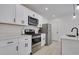 Modern kitchen with white cabinets, stainless steel appliances, and stylish light fixtures at 1452 Fletcher Ave, Indianapolis, IN 46203